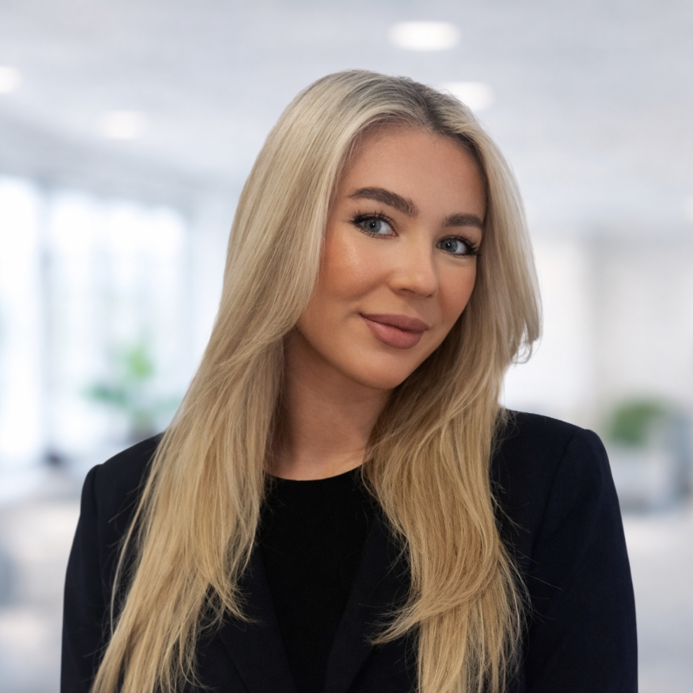 A woman with blonde hair wearing a black blazer over a black top.